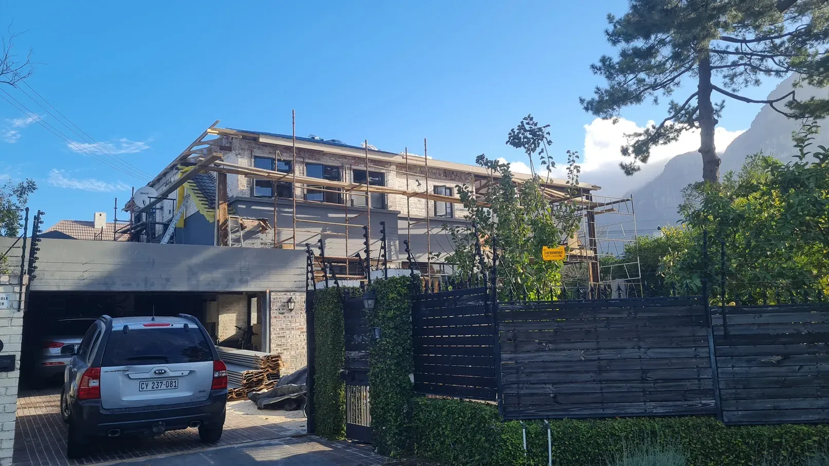 Double-storey home mid re-roof with scaffolding up and the roof structure exposed