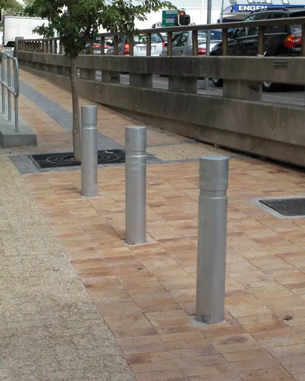 Round 150 flat-top galvanised steel bollards set into brick paving