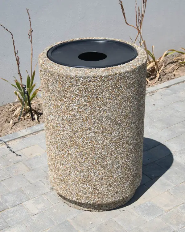 Round 600 precast concrete litter bin with a black moulded lid, on block paving
