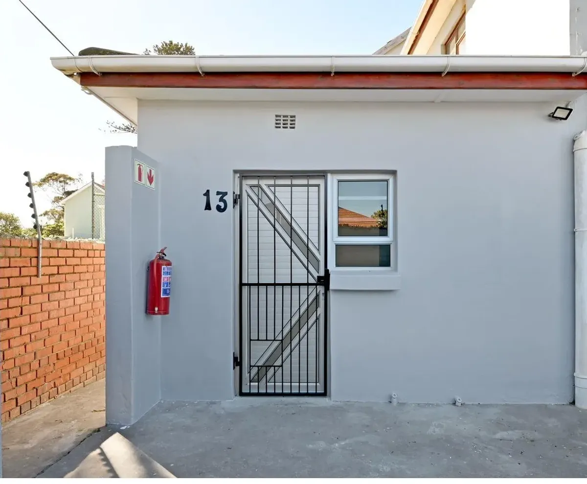 The Wynberg flat entrance after the renovation, repainted walls with a new security gate and window