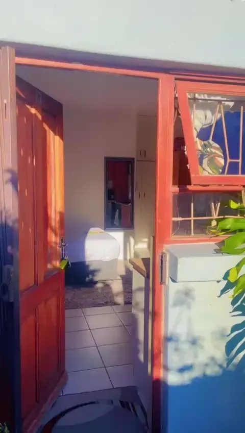 The Wynberg flat entrance before the renovation, an old timber door and painted frame